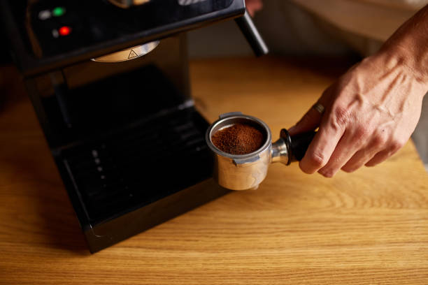 istock Male barista hand making espresso from ground coffee maker at modern cafe 1356764516