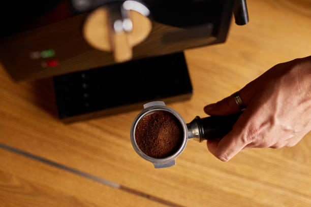 istock Male barista hand making espresso from ground coffee maker at modern cafe 1356764517