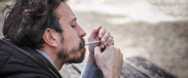 istock Man lighting up joint marihuana joint cigarette. Closeup detail view 1356769707