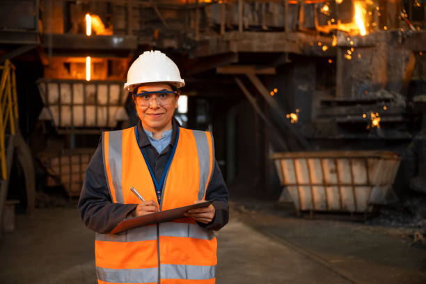 istock Mature woman standing in the foundry and taking notes 1356772423