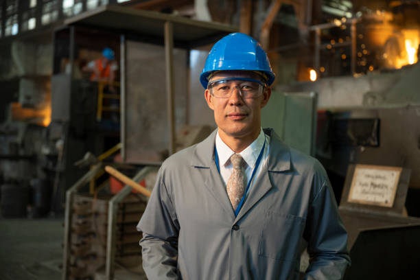 istock Smiling senior man standing in foundry 1356772445