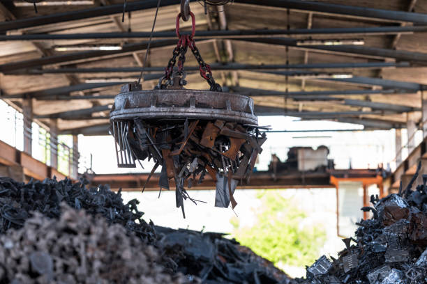 istock Scrap magnet picking up metal at recycling facility 1356772457