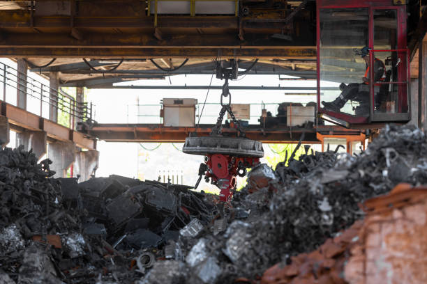 istock Scrap magnet picking up metal at recycling facility 1356772461