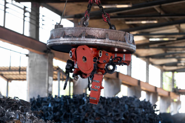 istock Scrap magnet picking up metal at recycling facility 1356772472