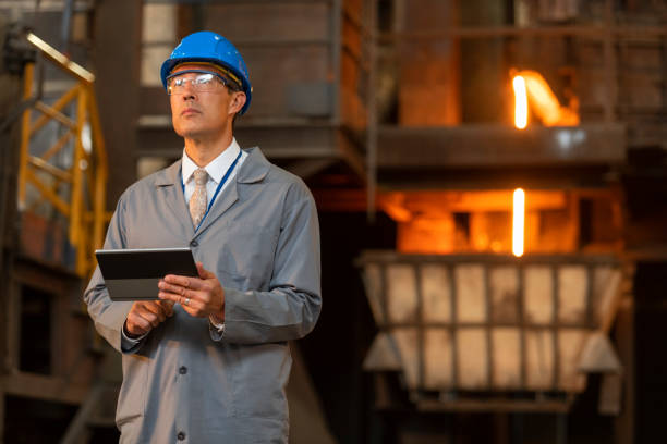 istock Mature man holding digital tablet in foundry 1356772496