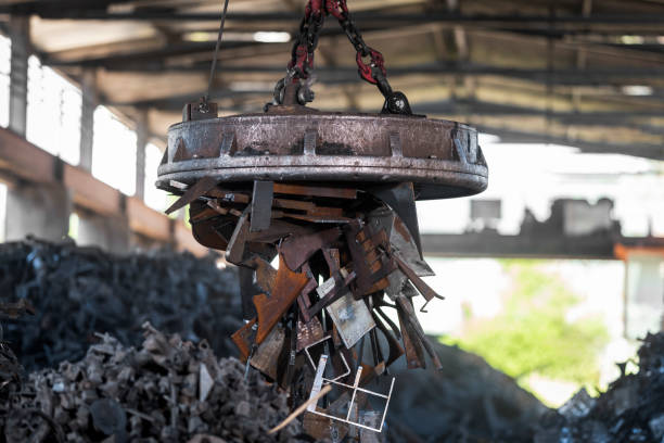 istock Scrap magnet picking up metal at recycling facility 1356772501