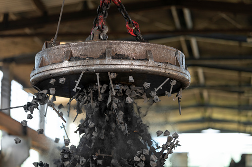 Close-up of industrial magnet picking up scrap metal at the recycling facility.