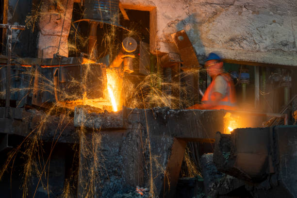 istock Foundry worker removing slag from molten metal in the foundry 1356772512
