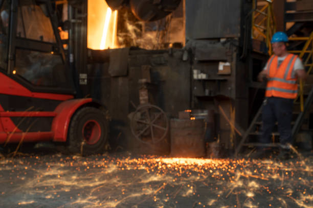 Soft focus of molten steel coming from the foundry ladle into a vessel inside the steel mill.