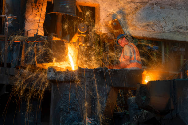 istock Foundry worker removing slag from molten metal in the foundry 1356772528