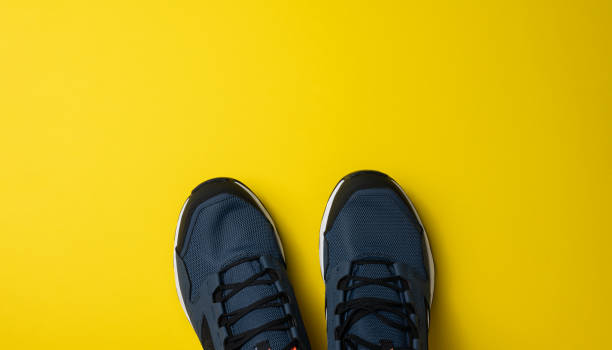 istock pair of blue textile sneakers on yellow background, top view 1356773549