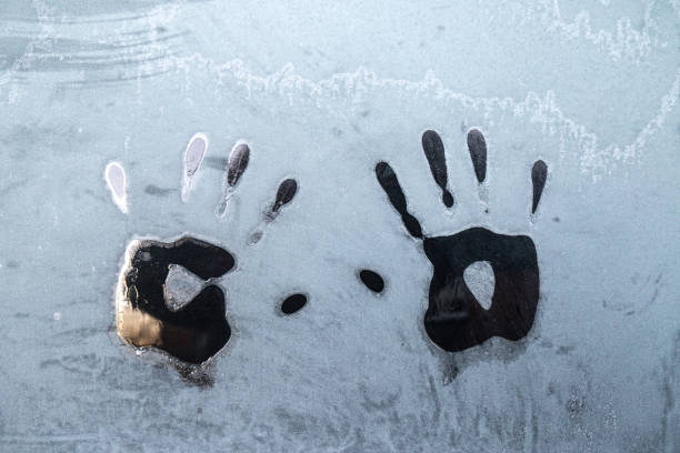 pair of handprints on frosty winter glass window, meted hand prints outdoors. - congelação imagens e fotografias de stock