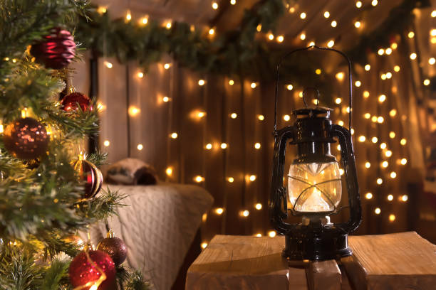 istock Christmas background with decorated Christmas tree and lantern.An old kerosene lamp on a background with a bokeh. 1356781420