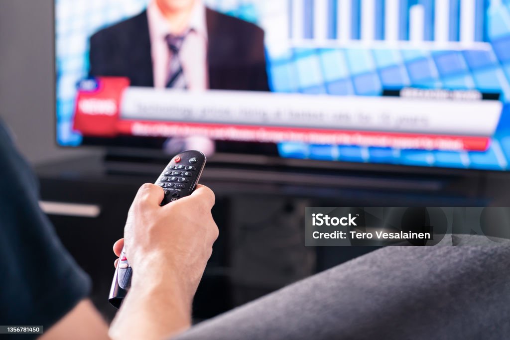 Breaking news on tv. Man watching live television broadcast program. Covid19, coronavirus and medical information or election reporter and presenter in world politics. Breaking news on tv. Man watching live television broadcast program. Covid19, coronavirus and medical information or election reporter and presenter in world politics. Financial journalist channel. Television Set Stock Photo