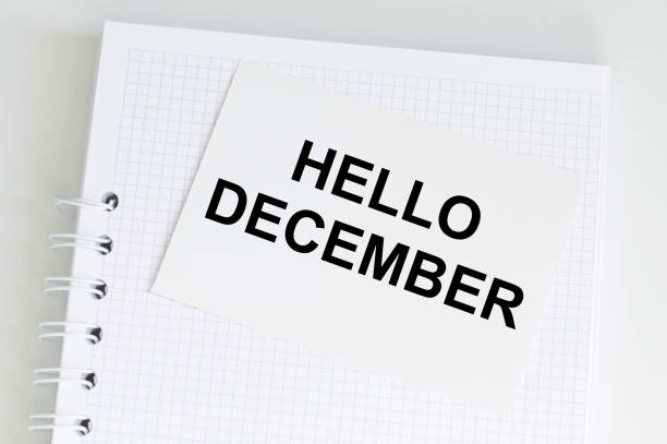 istock HELLO DECEMBER text on a card that lies on a notebook on a light table, business concept 1356783769