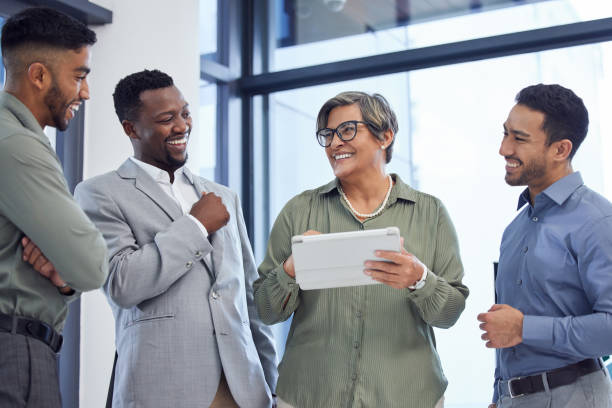istock Shot of a group of businesspeople using a digital tablet at work 1356784298
