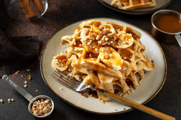 istock Banana waffles with walnuts and salted caramel in a plate on a culinary background 1356786617