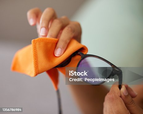 istock Shot of an unrecognizable person cleaning glasses at home 1356786984