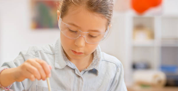 istock Girl doing chemical experiment in the laboratory 1356786989