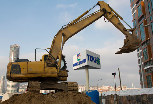 Istanbul, KADIKOY / Turkey - November 6, 2021: Istanbul urban transformation. Kadikoy district, Fikirtepe region. Construction work of new residences. Official institutions undertaking the construction of new buildings Emlak Konut and Toki (Republic of Turkey Mass Housing Administration) signboard. City, buildings and blue sky in background. Horizontal.
