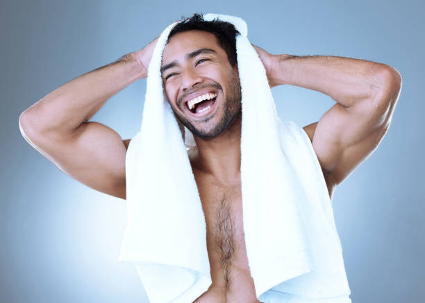 istock Studio shot of a handsome young man drying himself with a towel while posing against a grey background 1356790655