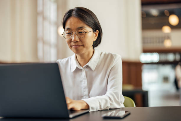 istock Considerate asian woman, quietly using an open coworking space 1356790876