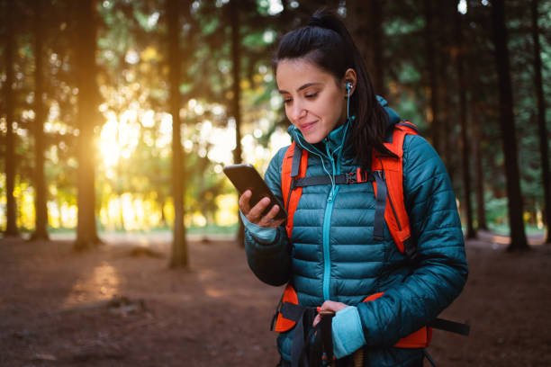 istock Caucasian active young woman, listening music and using mobile phone while hiking 1356792034
