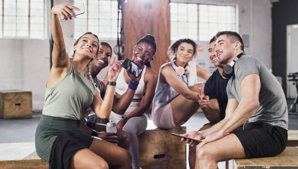 Shot of a group of friends relaxing and taking a selfie together at the gym stock photo