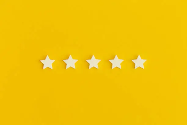 Photo of Five 5 stars, best excellent services rating on yellow background.