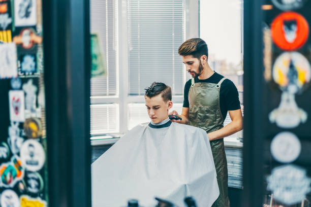 Barber shop Hairdresser working in hair salon teenager boy haircuts stock pictures, royalty-free photos & images