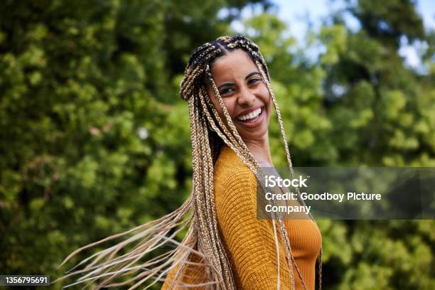 Laughing Young Woman Twirling Her Long Braided Hair Outside In Summer Stock Photo - Download Image Now