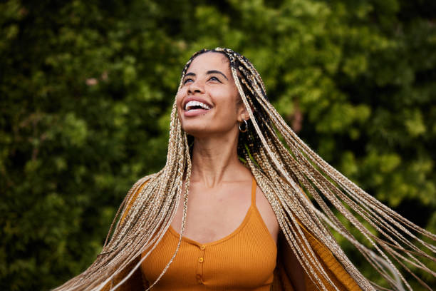laughing woman twirling her long braided hair outside in summer - braided braids women long hair imagens e fotografias de stock