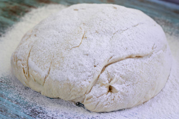 istock Fresh crude dough mixed and kneaded from wheat flour during baking 1356800294