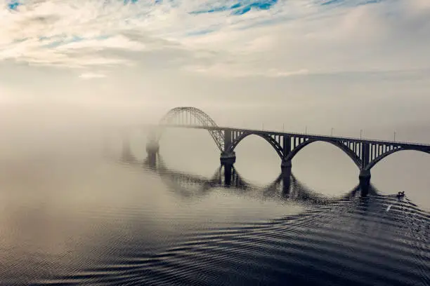Queen Alexandrine bridge or in Danish, Dronning Alexandrines Bro. Is the bridge that links the large island  Zealand with the small island of Moen. The island of Moen is a popular tourist attraction popular with Danes and northern-european holiday-makers looking for “back to nature” holiday. Photographed on a foggy morning in the early morning autumn light. Colour, horizontal format with some copy space.