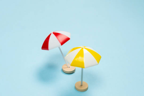 istock Yellow and red umbrella on a blue background. 1356800381