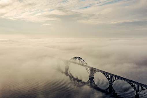 Queen Alexandrine bridge or in Danish, Dronning Alexandrines Bro. Is the bridge that links the large island  Zealand with the small island of Moen. The island of Moen is a popular tourist attraction popular with Danes and northern-european holiday-makers looking for “back to nature” holiday. Photographed on a foggy morning in the early morning autumn light. Colour, horizontal format with some copy space.