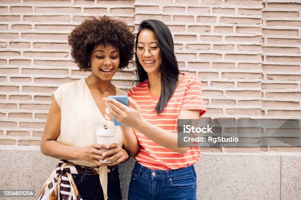 Best Friends Enjoying In Madrid Using Smartphone And Having Fun Stock Photo - Download Image Now