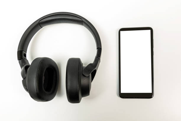 istock headphones with Bluetooth technology on white background, with black phone paired for music lovers 1356802662