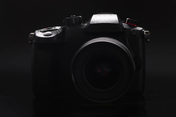 istock New photo camera on black background closeup 1356803318