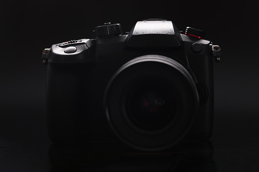 New photo camera on black background closeup. Sale of photographic equipment concept