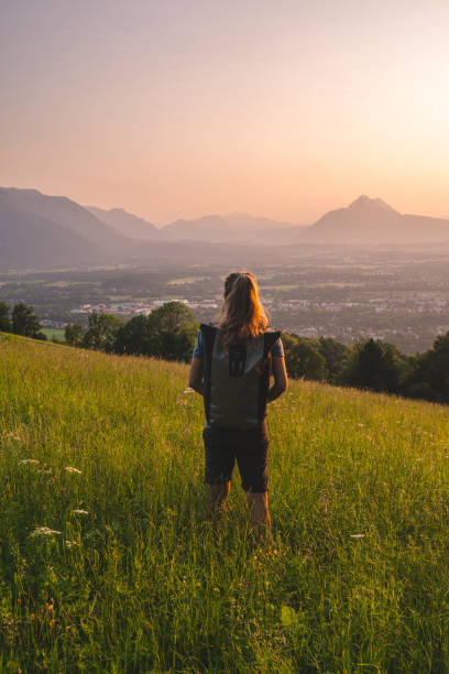 une randonneuse se détend sur la crête herbeuse de la montagne - hiking young women outdoors t shirt photos et images de collection