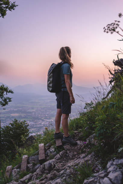 istock Female hiker relaxes on mountain at sunrise 1356804265