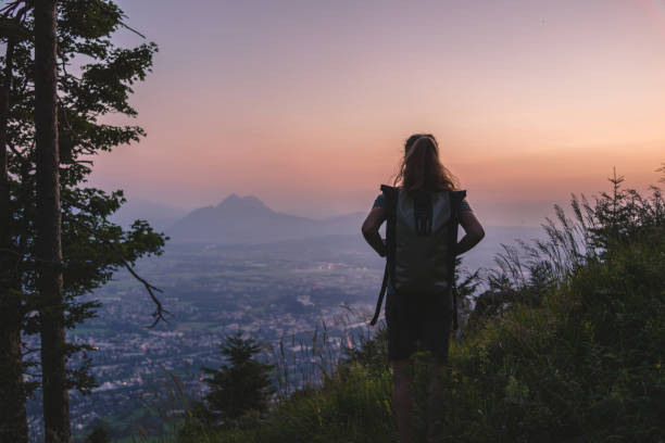 istock Female hiker relaxes on mountain at sunrise 1356804281