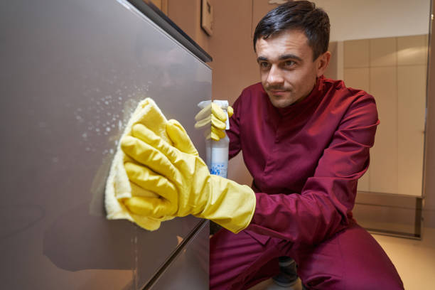 istock Experienced cleaner wiping shoe rack cabinet with damp microfiber cloth 1356804935
