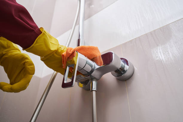 istock Gloved hands cleaning water faucet in bathroom 1356804954