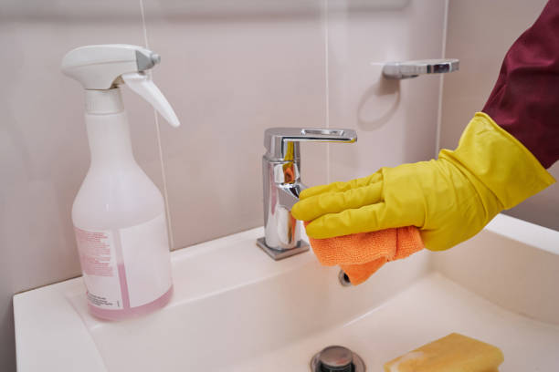 istock Gloved hand cleaning chrome faucet in bathroom 1356804957