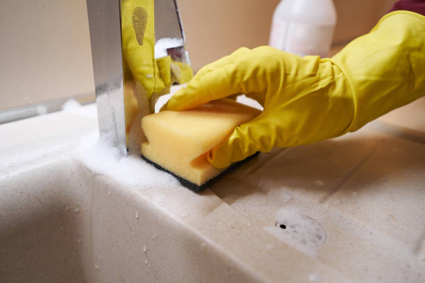 istock Professional janitor cleansing kitchen washbasin with liquid detergent 1356805044