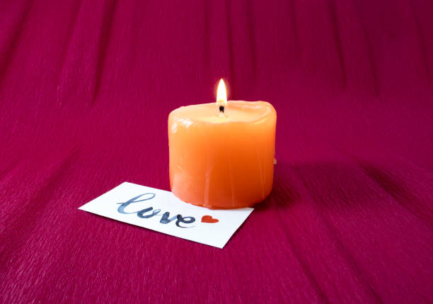 istock Candle with love card on red background 1356809018