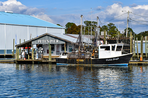 A small commercial fishing vessel is moored at a dock. The location is a store selling fuel and supplies on King's Bay in Florida.\nCrystal River, Florida\n11/19/2021
