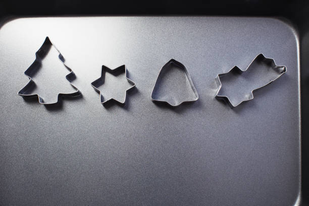 metal cookie cutters and black baking sheet